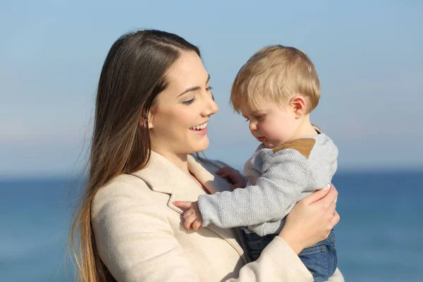 Madre holding suo arrabbiato figlio bambino su il spiaggia — Foto Stock