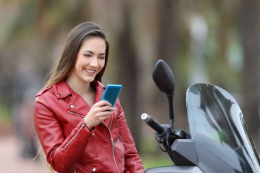 Telefon sokakta onun motosiklet üzerinde kontrol motorcu