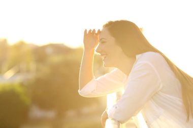 Kadın bir balkonda evde dört gözle