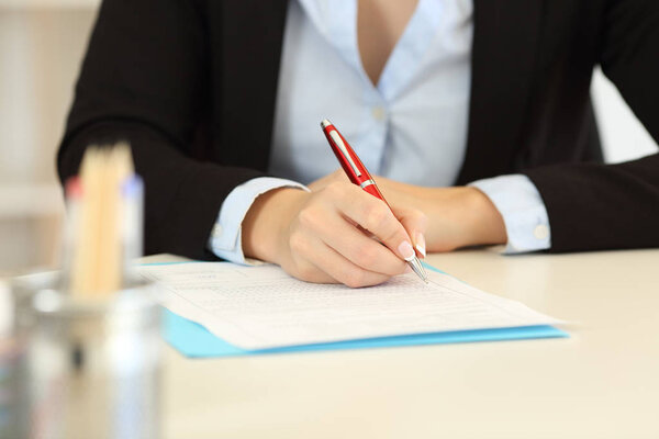 Close up of an office worker hands filling form