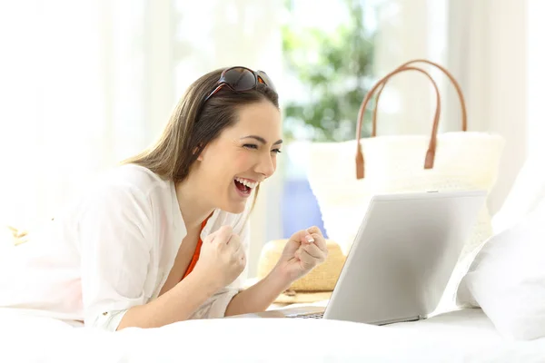 Opgewonden vrouw met behulp van een laptop in vakanties — Stockfoto