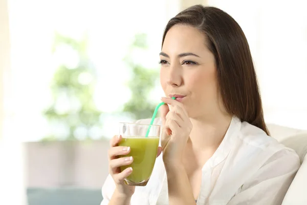 Chica beber jugo de verduras sorbiendo una paja — Foto de Stock