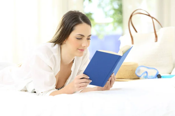 Расслабленная женщина, читающая книгу в отеле на отдыхе — стоковое фото