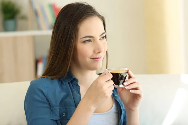 Расслабленная женщина пьет кофе и смотрит в сторону — стоковое фото