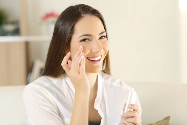 Mujer aplicando crema hidratante en la cara — Foto de Stock