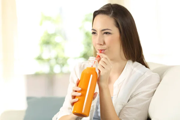 Женщина пьет апельсиновый сок с соломинкой — стоковое фото