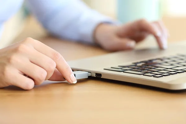 Mujer de la mano que conecta un pendrive en un ordenador portátil — Foto de Stock