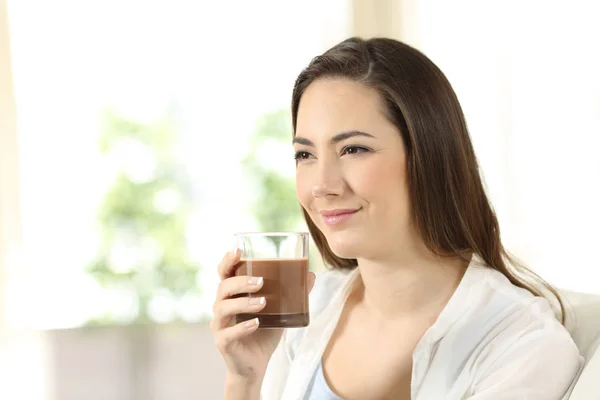 Mulher segurando um batido de cacau olhando para longe — Fotografia de Stock