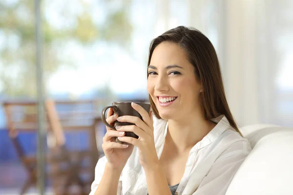 Frau blickt in Kamera mit Kaffeebecher — Stockfoto