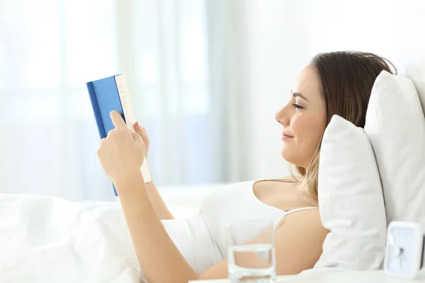 Žena čte knihu na postel — Stock fotografie