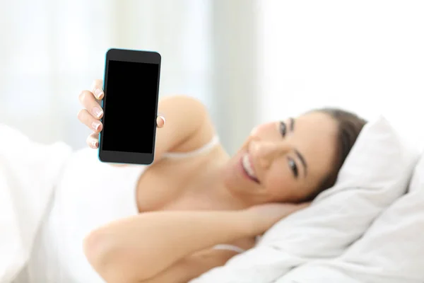 Mujer mostrando una pantalla de teléfono inteligente en la cama —  Fotos de Stock