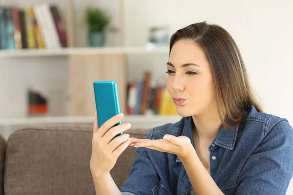 Mujer enviando un beso en línea con un teléfono —  Fotos de Stock