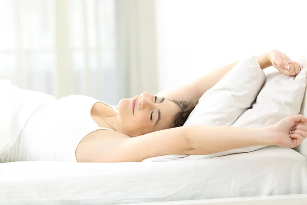 Woman stretching arms in the moring on the bed — Stock Photo, Image
