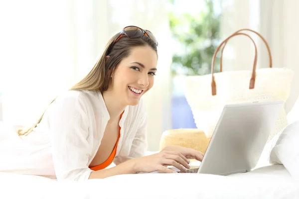 Mulher usando um laptop olhando para você em férias — Fotografia de Stock
