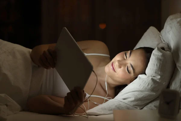 Mujer viendo los medios en una tableta en la noche —  Fotos de Stock