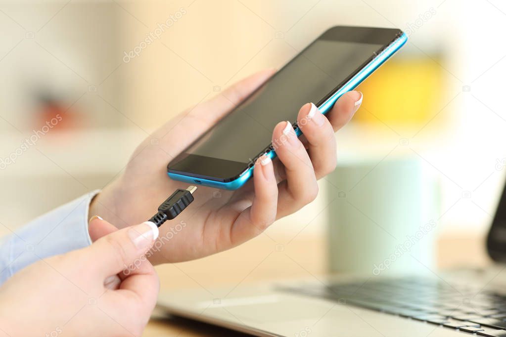 Woman hands plugging a charger on a smart phone