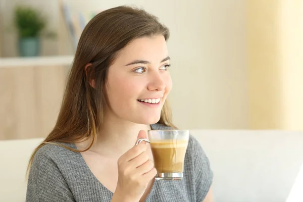 Feliz adolescente bebiendo café con leche mirando al lado —  Fotos de Stock