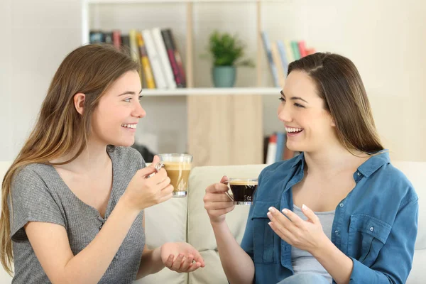 Двое друзей разговаривают и пьют кофе дома — стоковое фото