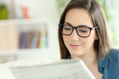 Bir gazete okuyor gözlük giyen kadın
