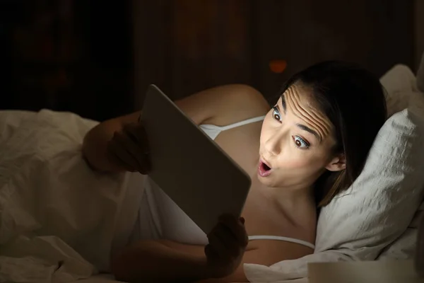 Amazed girl watchig media content in a tablet in the night — Stock Photo, Image