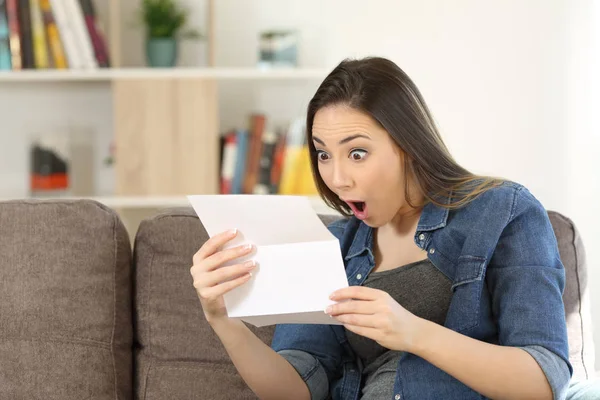 Mujer sorprendida leyendo noticias sorprendentes en una carta —  Fotos de Stock