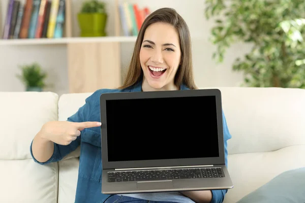 Wanita lucu menampilkan layar laptop kosong di rumah — Stok Foto