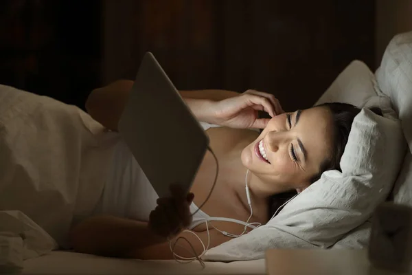 Girl watching online videos in a tablet at night — Stock Photo, Image