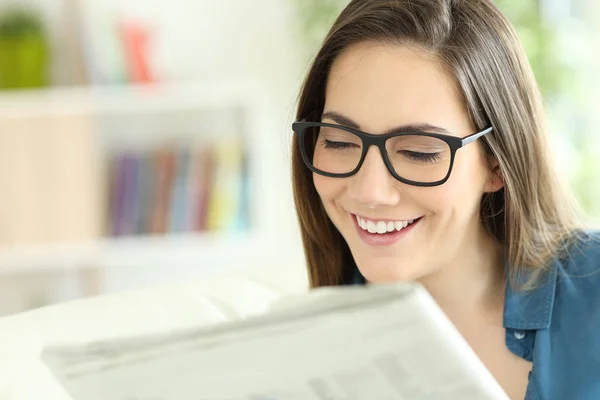 Senhora vestindo óculos lendo um jornal — Fotografia de Stock