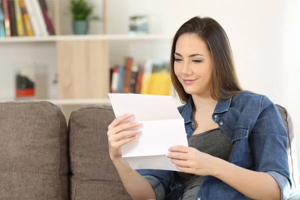 Mujer satisfecha leyendo una carta en casa —  Fotos de Stock