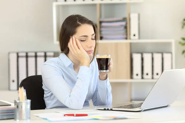 Somnolent udøvende drikke kaffe på kontoret - Stock-foto