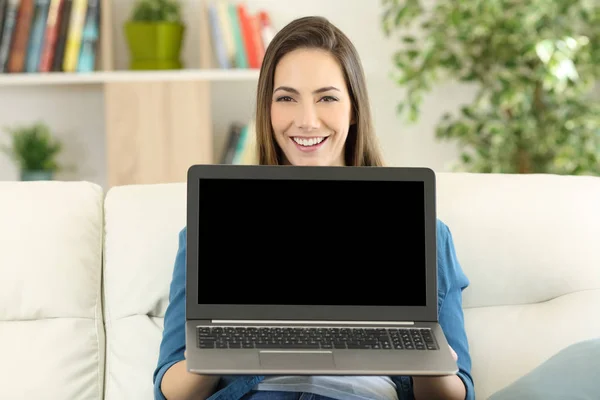 Mujer mostrando una pantalla portátil en blanco en casa — Foto de Stock
