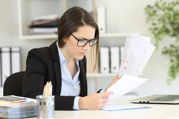 Worried office worker reading sales reports — Stock Photo, Image