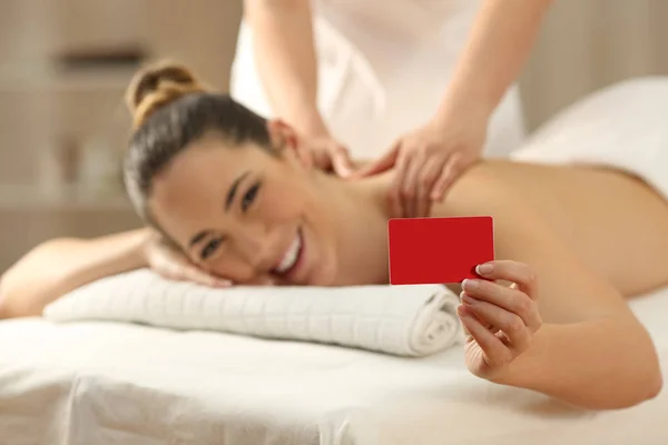 Woman receiving a massage showing credit card — Stock Photo, Image