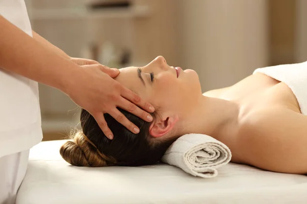 Mulher relaxante recebendo uma massagem facial — Fotografia de Stock