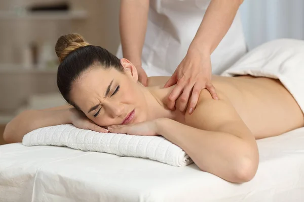 Mulher sofrendo receber uma massagem — Fotografia de Stock