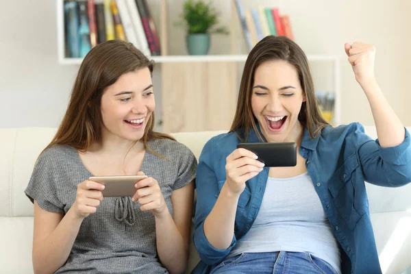 Zwei aufgeregte Freunde spielen Spiele und gewinnen — Stockfoto