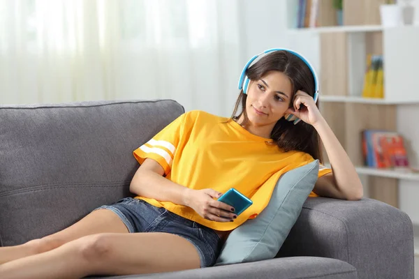 Entspannter Teenager hört Musik auf der Couch — Stockfoto