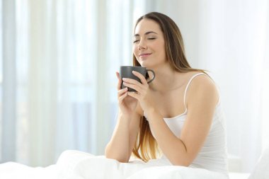 Kadın yatakta kahve tadını uyanma