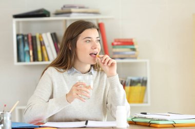 Evde yardım hastalık belirtileri için bir hap almaktan öğrenci