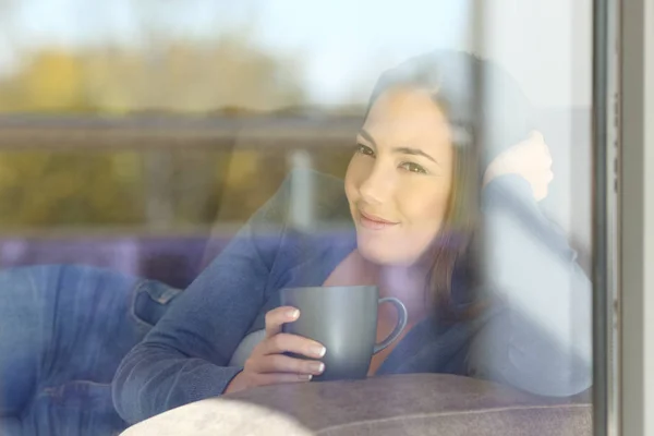 Femme détendue regardant à l'extérieur par une fenêtre — Photo