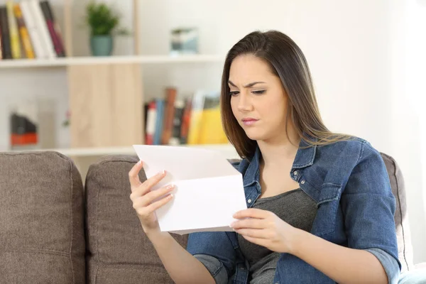 Mujer sospechosa leyendo una carta en casa — Foto de Stock