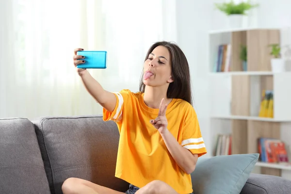 Verspielter Teenager macht Selfies auf einer Couch — Stockfoto