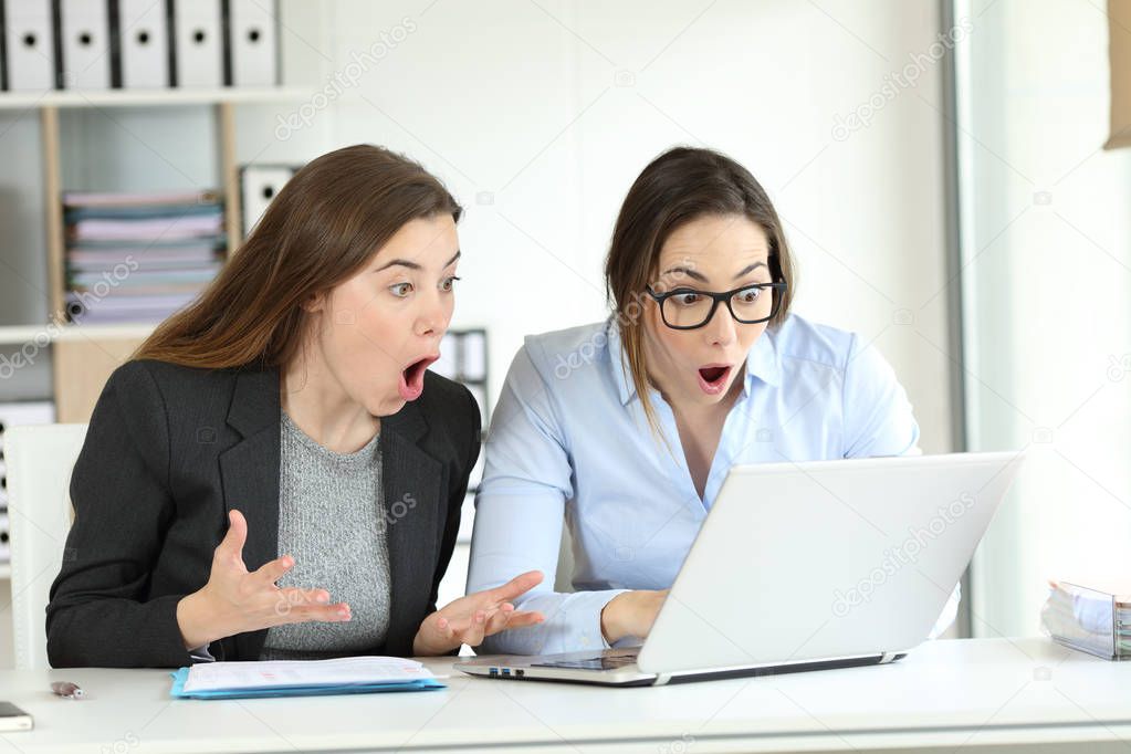 Surprised office workers reading online news