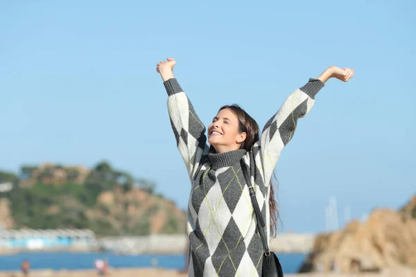 Fille excitée en hiver levant les bras sur la plage — Photo