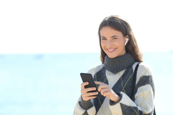 Ragazza felice ascoltare musica con auricolari wireless ti guarda — Foto Stock