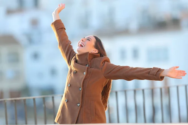 Femeia entuziasmată ridică brațele iarna într-un balcon — Fotografie, imagine de stoc