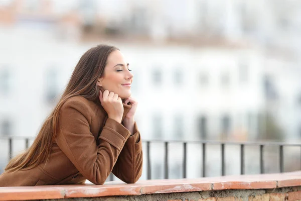 Satisfait femme chauffage en hiver fermer les yeux dans un balcon — Photo