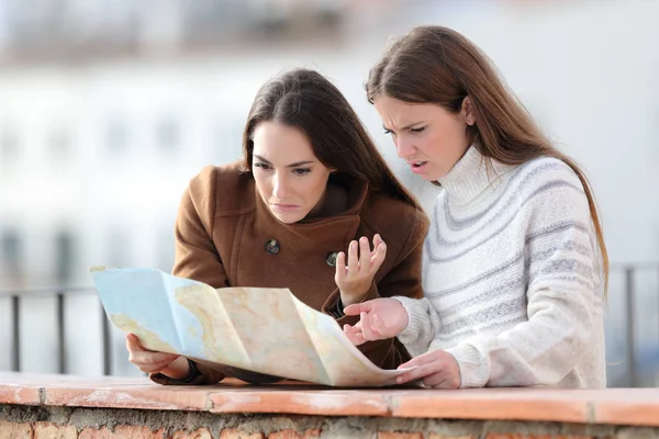 Turistas perdidos revisando mapa de papel en un balcón — Foto de Stock