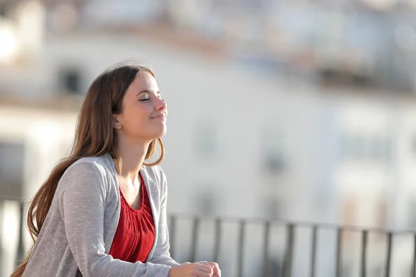 Entspannte Frau atmet frische Luft auf Balkon — Stockfoto