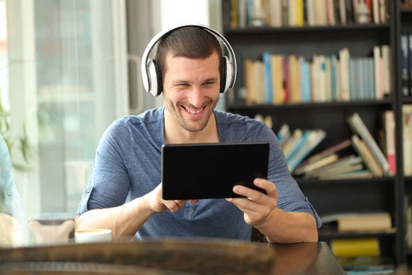Вид спереду щасливого чоловіка з навушниками за допомогою планшета — стокове фото